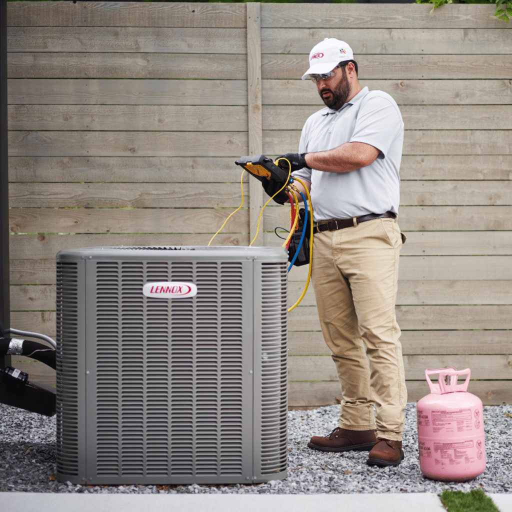 heater technician using manometer to perform maintenance on outdoor hvac unit