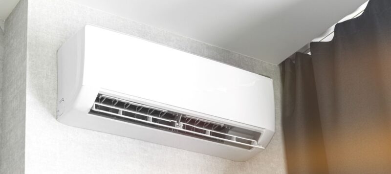 a white ductless ac unit installed at the top of an interior wall