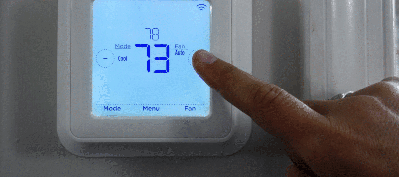 Homeowner adjusting thermostat while explaining the three-minute rule for air conditioners to prevent system damage